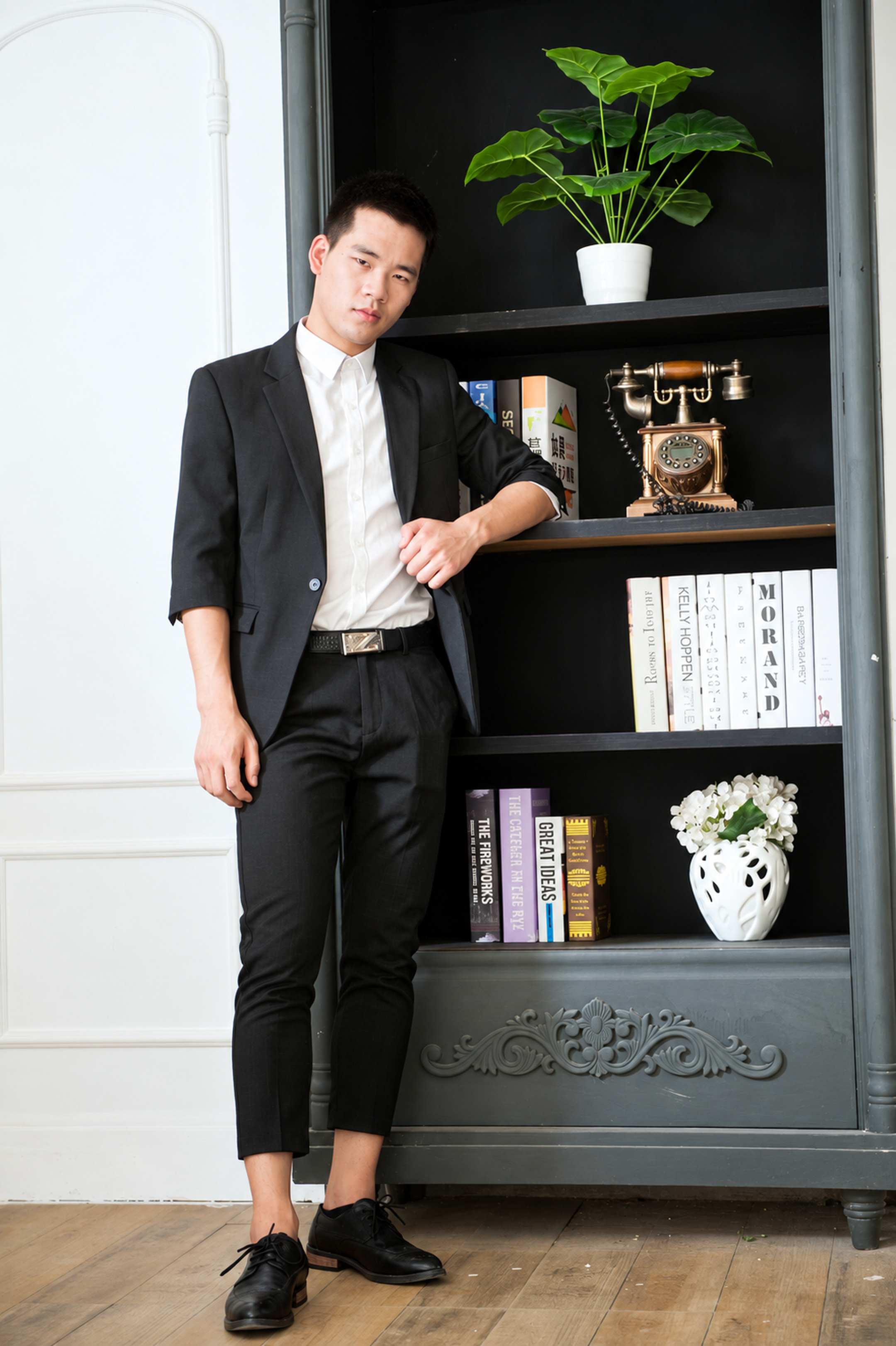 Portrait of Dr Yongxiang Lei in a dark suit beside a bookshelf